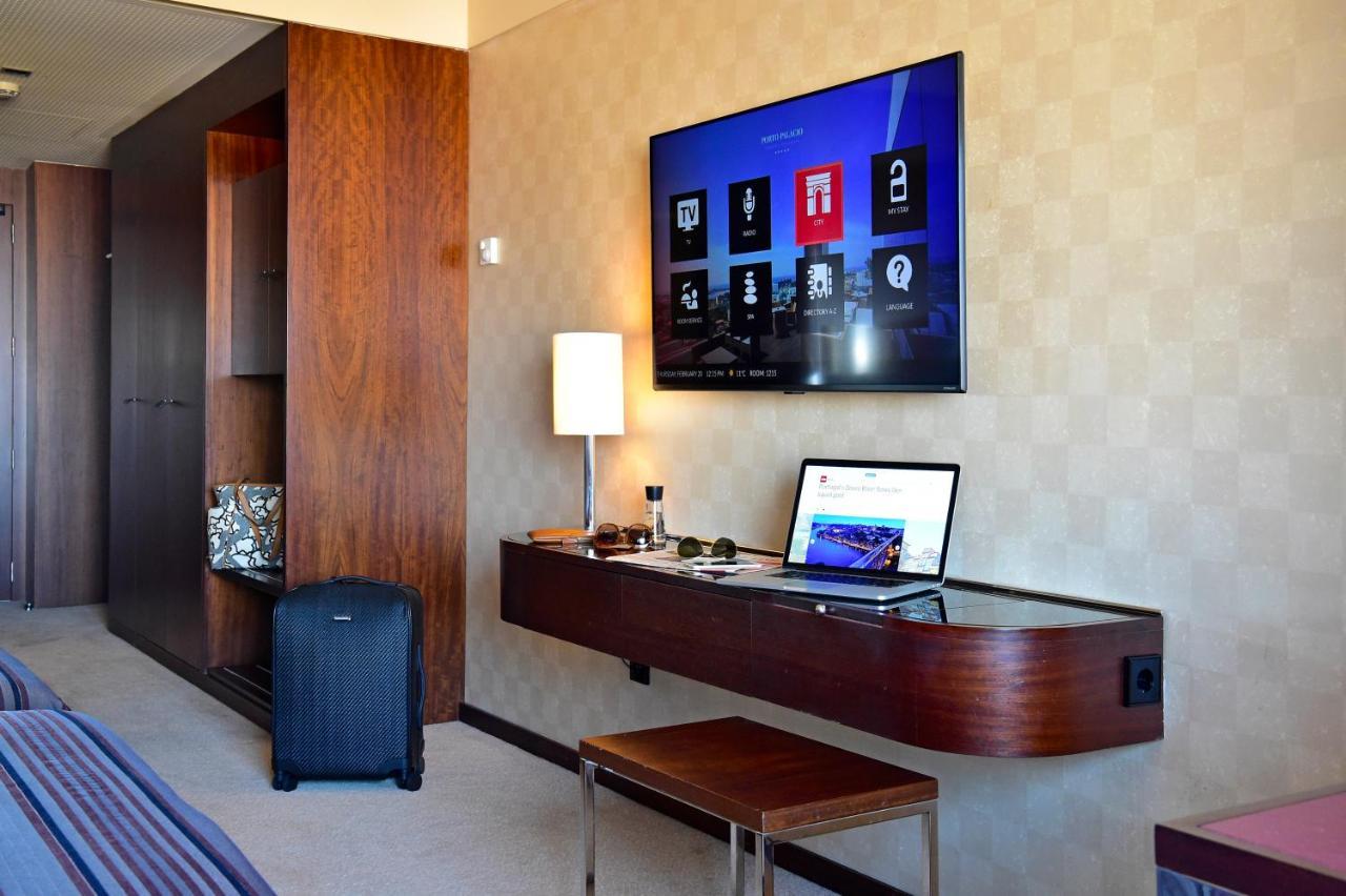 Porto Palacio Hotel By The Editory Exterior photo A hotel room with a TV and a laptop
